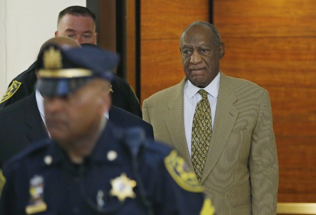 Bill Cosby, right, walks to the second floor of the Montgomery County Courthouse on his way to Courtroom A surrounded by Montgomery County police officers in Norristown, Pennsylvania, U.S. on July ...
