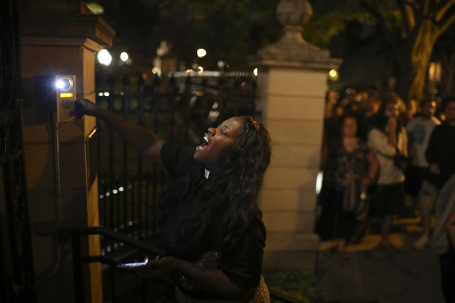 A woman rings the doorbell at the gate of the Governors Mansion as demonstrators gather in St. Paul, Minn., protesting a police-involved shooting early Thursday, July 7, 2016. (Jeff Wheeler/Star T ...
