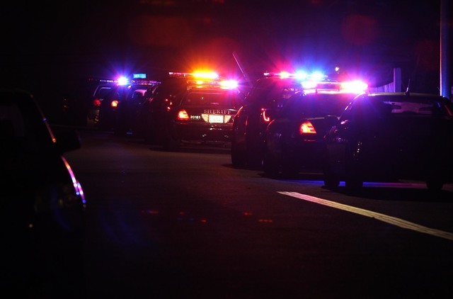 Police cars line the scene in San Diego near where two police officers were shot Thursday night, July 28, 2016. (John Gastaldo/The San Diego Union-Tribune via AP)