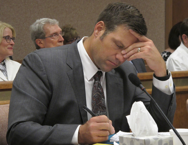 Kansas Secretary of State Kris Kobach listens and takes note as a judge declares in Shawnee County District Court that the state must count potentially thousands of votes from people who registere ...