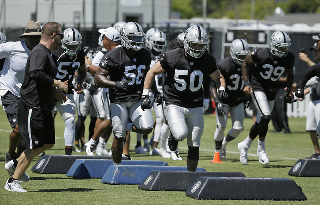 Oakland Raiders linebacker Ben Heeney (50) followed by Daren Bates (56) run through obstacles during practice at the NFL football team's training camp Friday, July 29, 2016, in Napa, Calif. (AP Ph ...