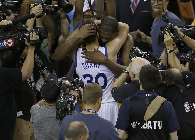 Golden State Warriors guard Stephen Curry (30) hugs Oklahoma City Thunder forward Kevin Durant after Game 7 of the NBA basketball Western Conference finals in Oakland, Calif., Monday, May 30, 2016 ...