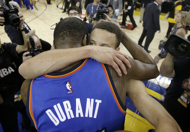 Oklahoma City Thunder forward Kevin Durant, foreground, hugs Golden State Warriors guard Stephen Curry after Game 7 of the NBA basketball Western Conference finals in Oakland, Calif., Monday, May  ...