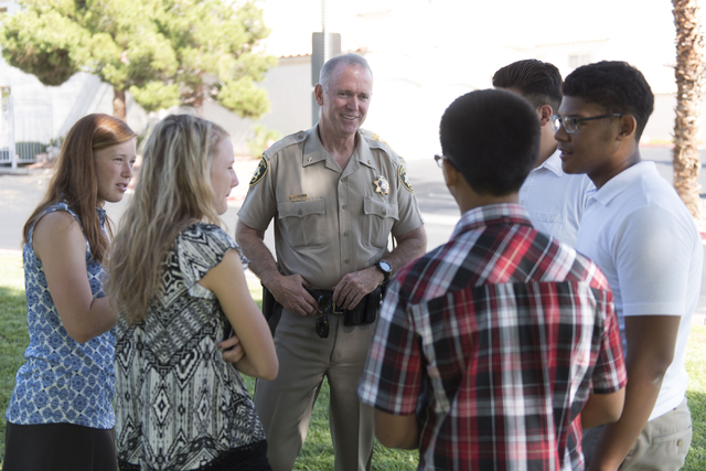 Las Vegas police Deputy Chief Jim Owens, center, speaks with a group of teenagers during an outreach event held at Torrey Pines Condominiums following Wednesday night's quadruple murder-suicide of ...