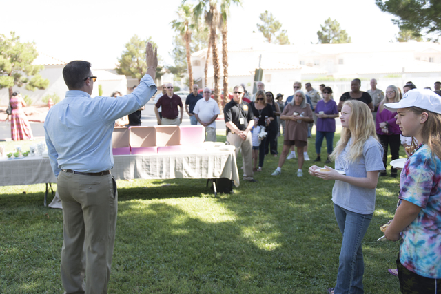 Pastor Matt Teis of Liberty Baptist Church, left, speaks to attendees during an outreach event held at Torrey Pines Condominiums following Wednesday night's quadruple murder-suicide of a family in ...