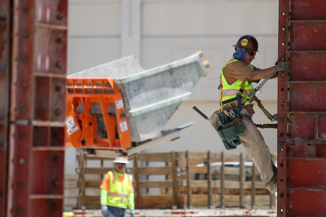 A contraction climbs a steel building column following a presentation hosted by the PENTA Building Group on the safety hazards heat brings at the Lucky Dragon casino-hotel construction site in Las ...