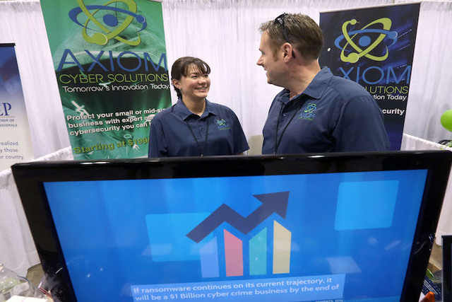 Axiom Cyber Solutions president Shannon Wilkinson, left, and her husband CEO Troy Wilkinson talks during the Business Expo sponsored by Las Vegas Metro Chamber at Cashman Field on Wednesday, June ...