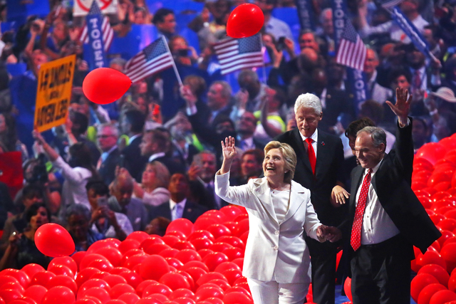 Democratic presidential nominee Hillary Clinton, left, former President Bill Clinton and Tim Kaine walk off stage through a sea of balloons during the final day of the Democratic National Conventi ...