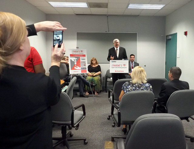 Rita Gallagher takes a photo of Kevin Malone as the Nevada Department of Motor Vehicles unveils a new program, The Parent's Supervised Driving Program, that will help parents teach their teens how ...