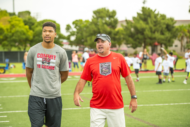 True freshman quarterback Armani Rogers, left, and football head coach Tony Sanchez talk during a youth football camp at Rebel Park on the campus of UNLV in Las Vegas on Friday, July 29, 2016. (Jo ...