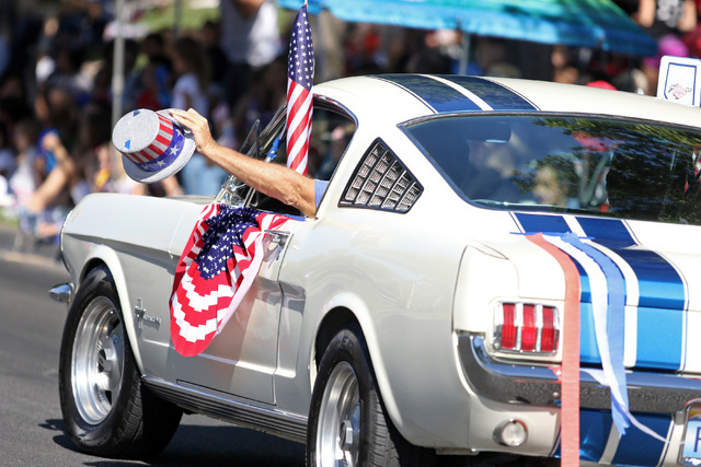 A driver in a procession with the classic Mustangs waves a patriotic hat during the 22nd Annual Summerlin Council Patriotic Parade Monday, July 4, 2016, in Las Vegas. (Ronda Churchill/Las Vegas Re ...