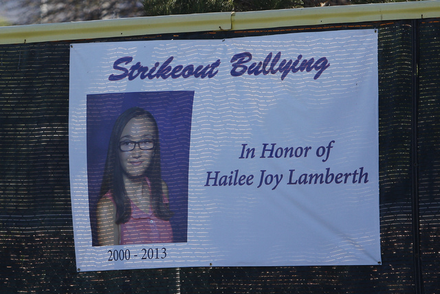 A sign on the outfield wall honors the memory of Hailee Joy Lamberth, the little girl who committed suicide as a result of being bullied, during a baseball game at the Arroyo Grande Sports Complex ...