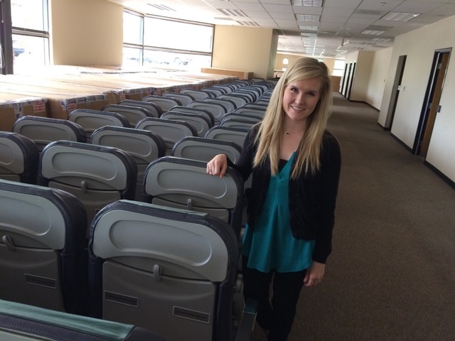 Kellie Wyatt, marketing special for Make-A-Wish, takes a seat May 17 in one of the airline seats currently in storage at the space Make-a-Wish will occupy as its new headquarters. The interior wil ...