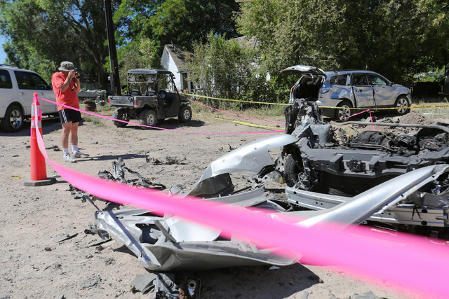 A man takes a photo of the damage from a Wednesday night bombing that killed one person in Panaca, Nev., tore a car in half and left a home uninhabitable on Friday, July 15, 2016. (Brett Le Blanc/ ...