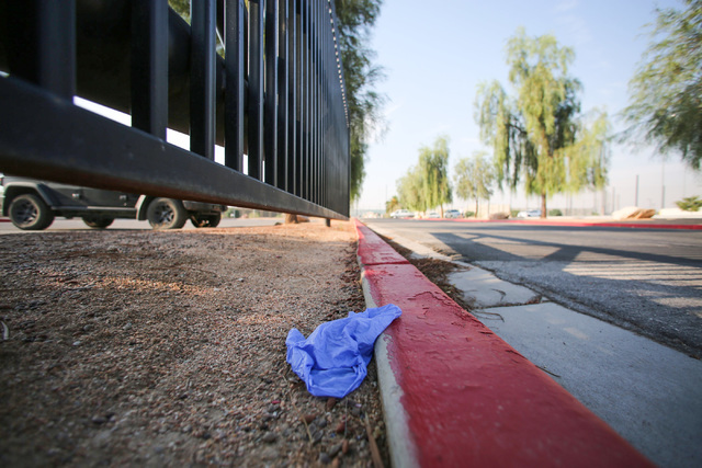 A medical glove lies discarded on a curb at Big League Dreams park near where Las Vegas police say a shooting erupted when a man in a vehicle attempted to rob Pokemon Go players early Monday morni ...