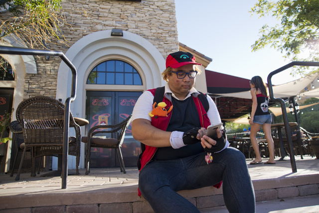 Julian Abrera uses the Pokemon Go app during a Pokemon Go &quot;Meet and Eat&quot; event at Lake Las Vegas on Tuesday, July 19, 2016. The event was organized by Chanthy Walsh who owns two  ...