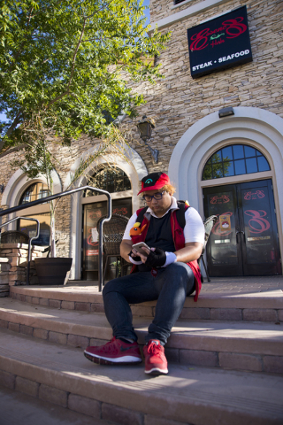 Julian Abrera uses the Pokemon Go app during a Pokemon Go &quot;Meet and Eat&quot; event at Lake Las Vegas on Tuesday, July 19, 2016. The event was organized by Chanthy Walsh who owns two  ...