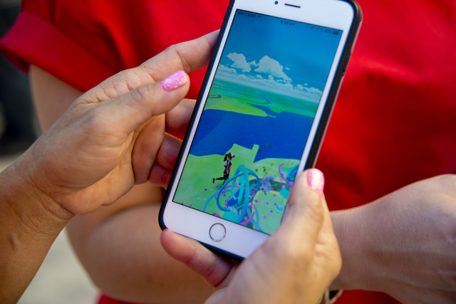Chanthy Walsh demonstrates the Pokemon Go app during a Pokemon Go &quot;Meet and Eat&quot; event at Lake Las Vegas on Tuesday, July 19, 2016. The event was organized by Walsh who owns two  ...