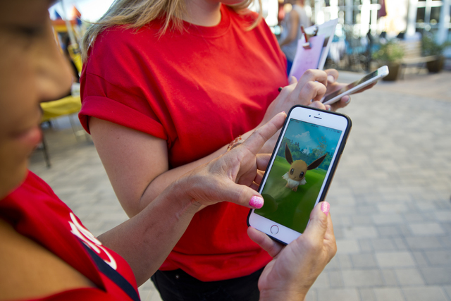 Chanthy Walsh demonstrates the Pokemon Go app during a Pokemon Go &quot;Meet and Eat&quot; event at Lake Las Vegas on Tuesday, July 19, 2016. The event was organized by Walsh who owns two  ...