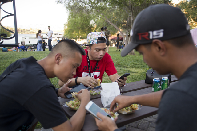 Ray Vasquez, from left, Carlo Saledo, and Manu Carag use the Pokemon Go app during a &quot;Meet and Eat&quot; event at Lake Las Vegas on Tuesday, July 19, 2016. The event was organized by  ...