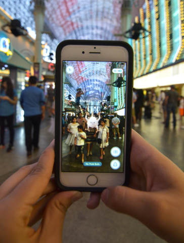 Review-Journal Digital News Editor Ashley Casper plays "Pokemon Go" along the Fremont Street Experience in downtown Las Vegas on Wednesday, July 13, 2016. (Bill Hughes/Las Vegas Review-Journal)