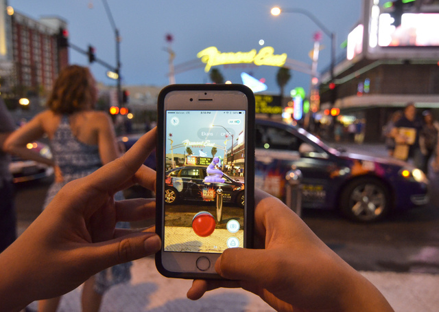 Review-Journal Digital News Editor Ashley Casper plays "Pokemon Go" along the Fremont Street in downtown Las Vegas on Wednesday, July 13, 2016. (Bill Hughes/Las Vegas Review-Journal)