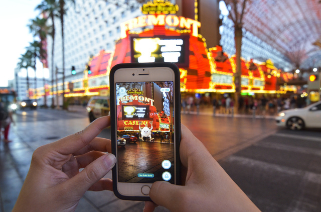 Review-Journal Digital News Editor Ashley Casper plays "Pokemon Go" along the Fremont Street Experience in downtown Las Vegas on Wednesday, July 13, 2016. (Bill Hughes/Las Vegas Review-Journal)