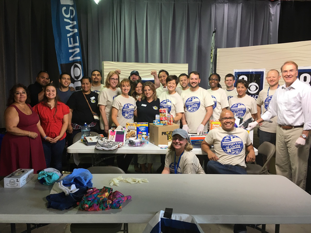 Channel 8 employees and Project 150 volunteers show off the items collected during a donation drive to benefit the nonprofit in June 2016. Special to View