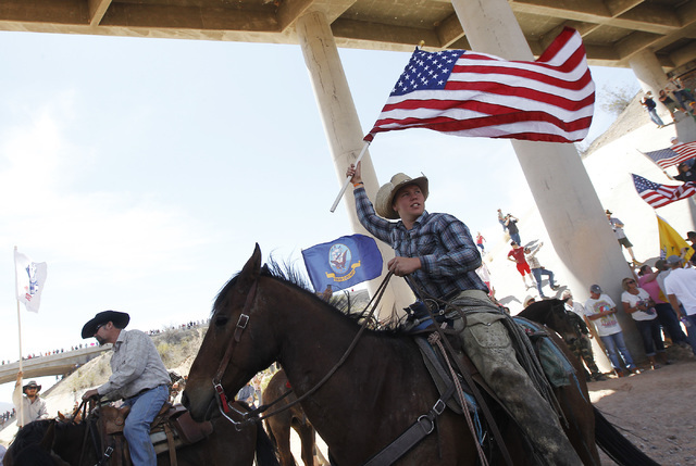 Arden Bundy, son of rancher Cliven Bundy, flies the American flag under the I-15 highway near Bunkerville after the BLM agreed to release his family's cattle on April 12, 2014. (Jason Bean/Las Veg ...