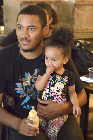 Marquis Ealy and his daughter Amelia listen to poetry during an event sponsored by the Battle Born slam poetry team at The Beat Coffeehouse and Records at 520 Fremont St. in Las Vegas on Friday, J ...