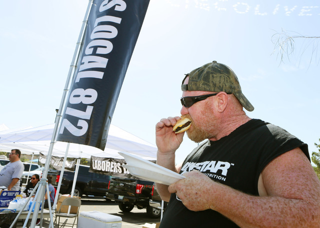 Fireproofer and Raiders football fan Joe Mulvaney eats a hamburger during a cook-out run by Laborers 872 in the parking lot where a meeting of the Southern Nevada Tourism Infrastructure Committee ...