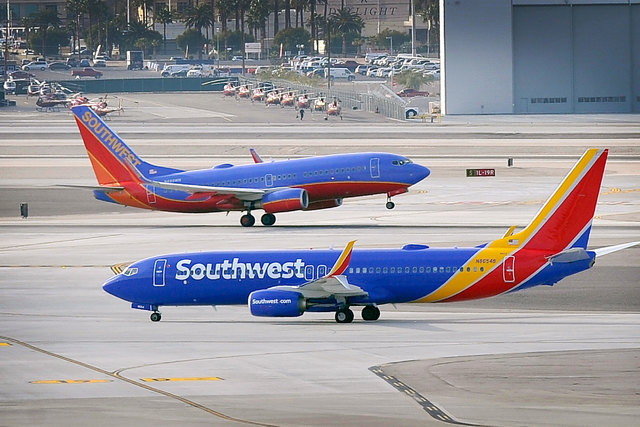 Two Southwest Airlines jets pass each other as one departs and the other taxis at McCarran International airport in Las Vegas on Jan. 12, 2015. (David Becker/Las Vegas Review-Journal)