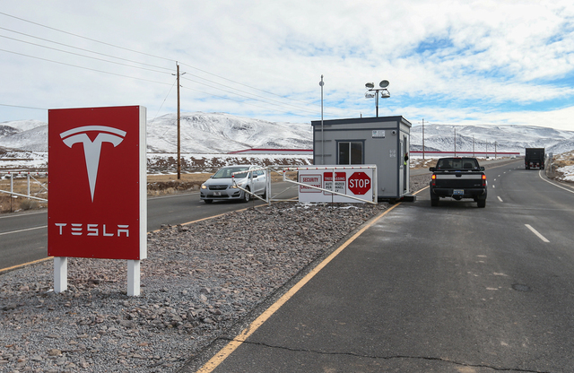 Traffic moves past the main gate of the Tesla gigafactory in the Tahoe-Reno Industrial Center, east of Sparks, Nev. on Wednesday, Feb. 3, 2016. The approximately 10 million square foot lithium-ion ...