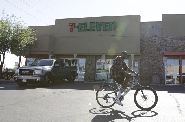 A man rides his bike through the parking lot of a 7-Eleven near 28th Street and Charleston Boulevard where a man was shot and killed early Thursday, July 7, 2016. (Bizuayehu Tesfaye/Las Vegas Revi ...