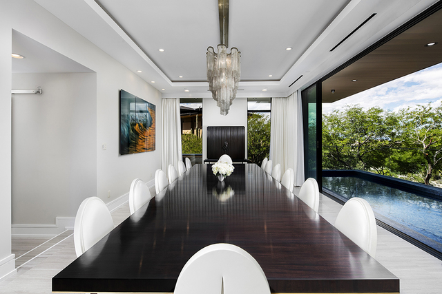 A 14-seat dining table can be found in the dining room on the main level and pocket doors open to bring the outdoors in. (Courtesy of Shapiro & Sher Group)