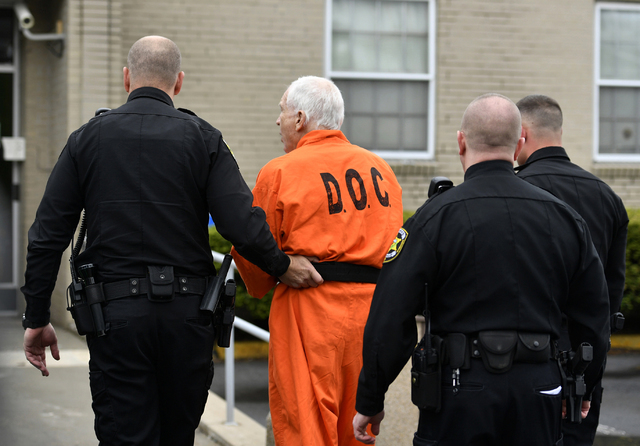 Former Penn State University assistant football coach Jerry Sandusky, second from left, arrives at the Centre County Courthouse for arguments on his request for an evidentiary hearing in Bellefont ...