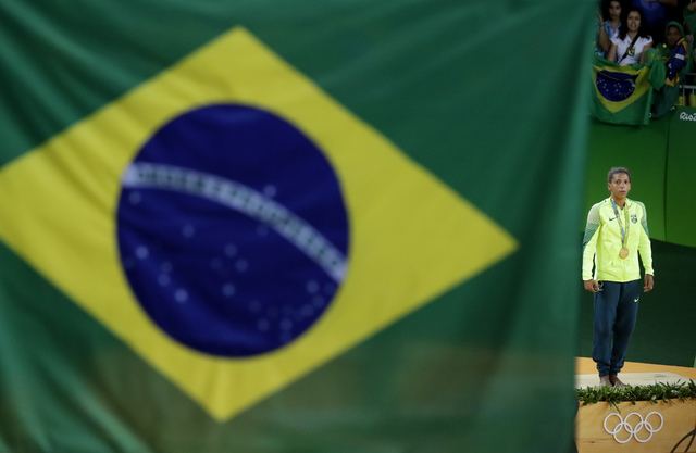 Rafaela Silva stands on the podium after winning the gold medal in the women's 57 kg judo competition of the 2016 Summer Olympics in Rio de Janeiro, Brazil, Monday, Aug. 8, 2016. (AP Photo/Gregory ...