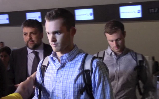 In this image made from video, American Olympic swimmers Gunnar Bentz and Jack Conger walk in the departure area after checking into their flight at the airport in Rio de Janeiro, Brazil, Thursday ...