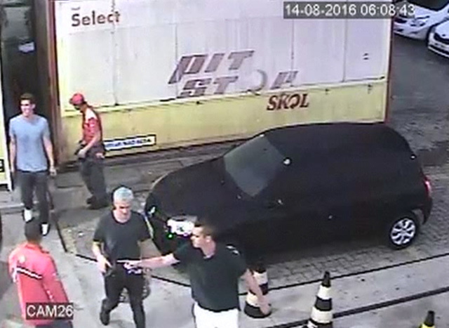 In this Sunday, Aug. 14, 2016 frame from surveillance video released by Brazil Police, swimmer Ryan Lochte, second from right, of the United States, and teammates, appear at a gas station duri ...
