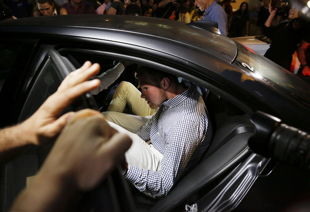 American Olympic swimmer Jack Conger gets into a car as he and fellow swimmer Gunnar Bentz leave a police station in the Leblon neighborhood of Rio de Janeiro, Thursday, Aug. 18, 2016. (Leo Correa/AP)