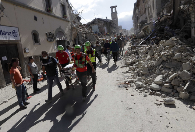 The body of a victim is pulled out of the rubble following an earthquake in Amatrice Italy, Wednesday, Aug. 24, 2016. (Alessandra Tarantino/AP)