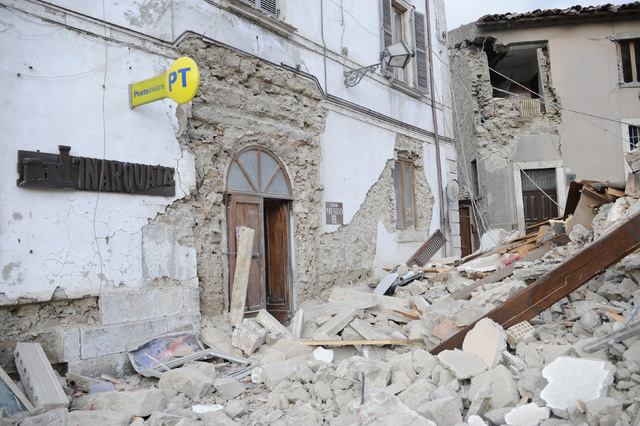 A post office is engulfed by rubbles in Arcuata del Tronto, central Italy, where a 6.1 earthquake struck just after 3:30 a.m., Wednesday, Aug. 24, 2016. The quake was felt across a broad section o ...