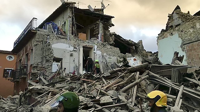 This still image taken from video shows rescuers searching a collapsed building in Amatrice, central Italy, where a 6.1 earthquake struck just after 3:30 a.m., Wednesday, Aug. 24, 2016. (AP Photo)