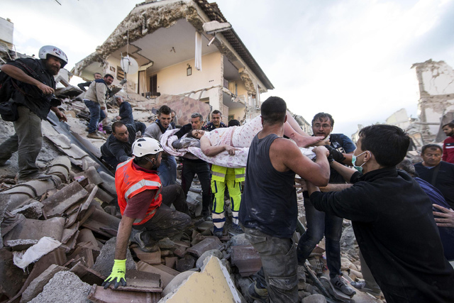 A woman is pulled out of the rubble following an earthquake in Amatrice Italy, Wednesday, Aug. 24, 2016.  The magnitude 6 quake struck at 3:36 a.m. (0136 GMT) and was felt across a broad swath of  ...