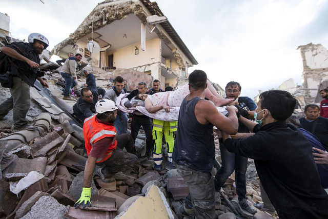 A woman is pulled out of the rubble following an earthquake in Amatrice Italy, Wednesday, Aug. 24, 2016. The magnitude 6 quake struck at 3:36 a.m. (0136 GMT) and was felt across a broad swath of ...