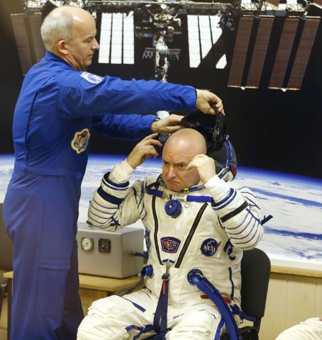 In this Friday, March 27, 2015 file photo, U.S. astronaut Jeff Williams, left, helps fellow astronaut Scott Kelly, a crew member of the mission to the International Space Station, put on his helme ...