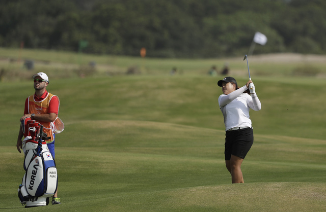 Inbee Park, a Bishop Gorman product, hits to the ninth green as her caddie Bradley Beecher looks on at the 2016 Summer Olympics in Rio de Janeiro, Friday, Aug. 19, 2016. (Alastair Grant/AP)