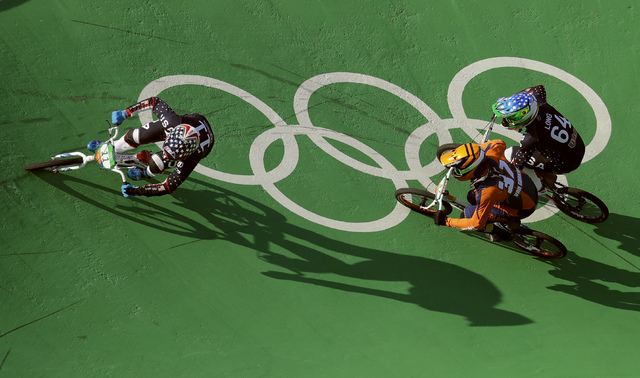 Connor Fields of the United States, left, leads in the last turn before the finish line to win gold in in the men's BMX cycling final followed by Jelle van Gorkom of the Netherlands, center, and N ...