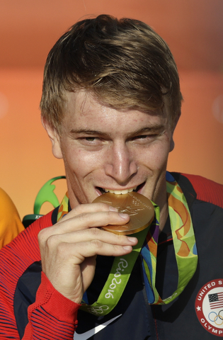 Connor Fields of the United States bites his gold medal on the podium ceremony of the men's BMX cycling final during the 2016 Summer Olympics in Rio de Janeiro, Brazil, Friday, Aug. 19, 2016. (AP  ...