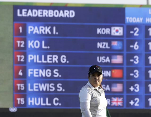 Inbee Park of South Korea stands in front of the leaderboard as she waits to play on the 18th hole during the third round of the women's golf event at the 2016 Summer Olympics in Rio de Janeiro, F ...